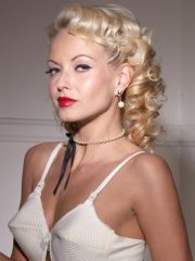 Blonde pinup Jana Cova dressed in retro lingerie playing with her pearl necklace