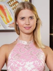 Beautiful blonde Violette strips and poses naked on the brown chair