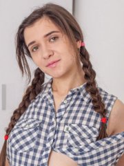 Gorgeous brunette Alesya strips off her shorts and panties in the bedroom